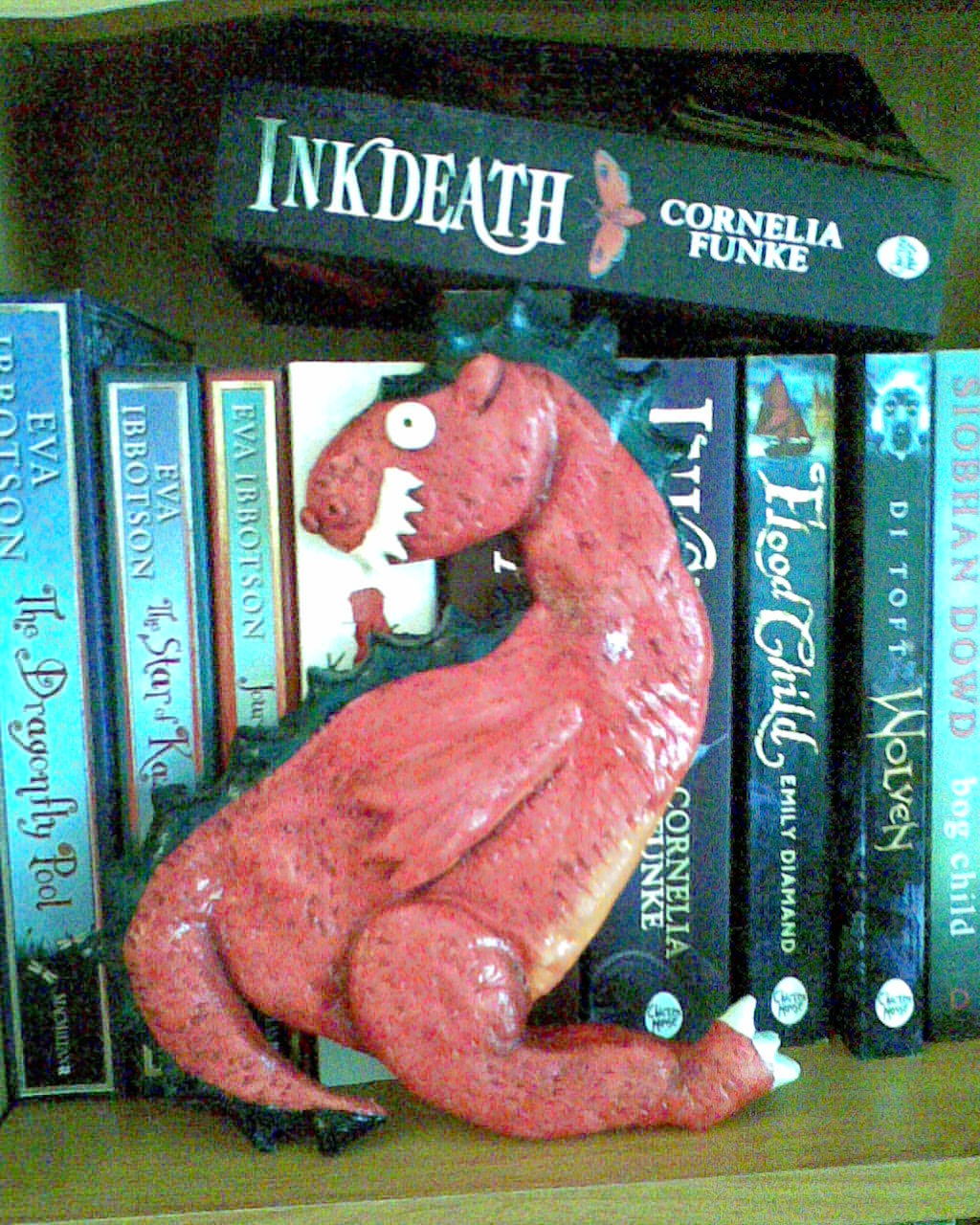 Photo of dough dragon and books on shelf